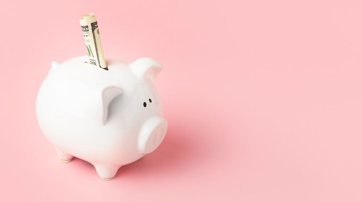 Piggy bank with a rolled dollar bill representing saved money